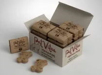 A box of Derma-Pure for larger breeds sat on a white table with open lead, so the smaller wrapped contents can be seen, with a couple of chews open on the table